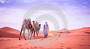 Camel rider with camels travelling over dunes in the desert