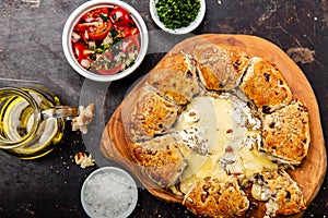 Camembert baked in the oven with herb bread served with tomato salad