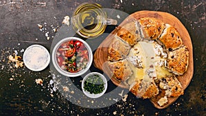 Camembert baked in the oven with herb bread served with tomato salad