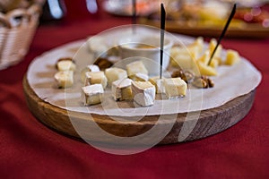 Camembert cheese cut into pieces on a wooden stand
