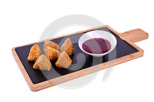 Camembert cheese fried in batter and breadcrumbs with cranberry sauce. Soft and viscous inside.On a wooden board on a
