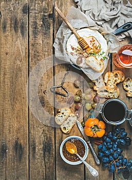 Camembert cheese, fruits, bread, honey, jam and wine, copy space