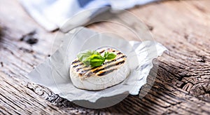 Camembert cheese. Grilled camembert cheese with olive oil and basil leaves