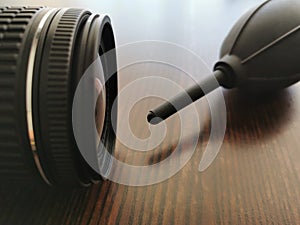 Camera and air blower on wood table.