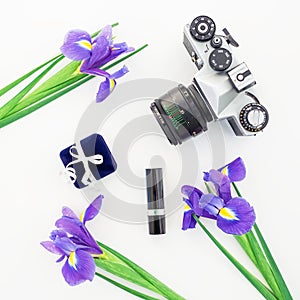 Camera and blue flowers, ring box, lipstick on white background. Flat lay.