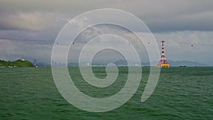 Camera on boat speeds across azure sea along rope-way