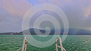 Camera on Boat Speeds across Azure Sea along Rope-way