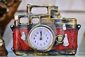 A camera with a clock instead of a lens is a concept of a time machine. Red gift transfers to the past or future