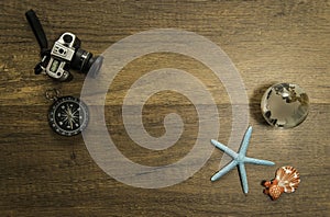 Camera and compass decorate on wooden table with starfish world glass marble and turtle