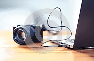 Camera connected to laptop with usb cable. File transfer to computer from DSLR. Back up storage for photos.