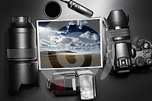 Camera equipment around a printed photo of a beach on a windy day.