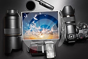 Camera equipment around a printed photo of a sunrise.