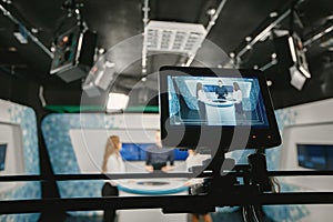 Camera filming tv show with host and two women