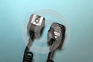 Camera flash sync cable on blue background