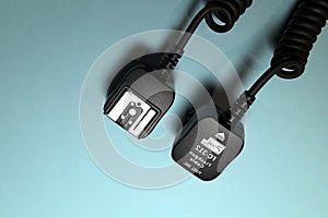 Camera flash sync cable on blue background