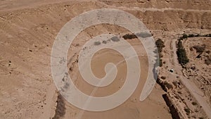 Camera flies over the dried out bed of Naquibs Pond in Wadi Hanifa near Riyadh