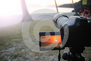 The camera with flip screen while recording a video view of the sunrise on the beach