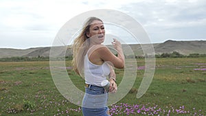 Camera follow hipster young woman in white t-shirt short jeans fluttering long hair. One girl dancing to the portable