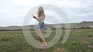 Camera follow hipster young woman in white t-shirt short jeans fluttering long hair. One girl dancing to the portable