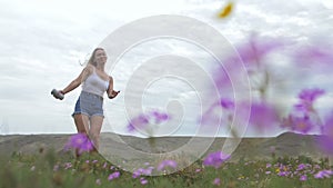 Camera follow hipster young woman in white t-shirt short jeans fluttering long hair. One girl dancing to the portable