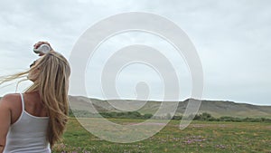 Camera follow hipster young woman in white t-shirt short jeans fluttering long hair. One girl dancing to the portable