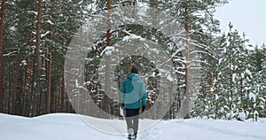 the camera follows a man who walks with his dog Kurtzhaar in a winter forest