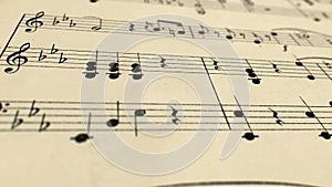 Camera glide and sway over old yellowed music score, close up