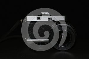 Camera and lens on a black background.