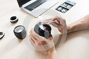 Camera lens cleaning with wet wipe, close-up