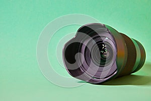 camera lens with glare on the front lens on a green background photo