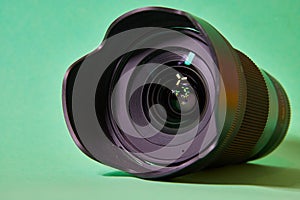 camera lens with glare on the front lens on a green background photo