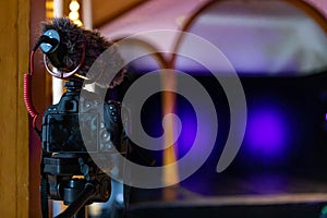 Camera with microphone on a stand aiming the stage photo