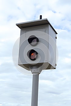 Camera monitoring the speed of cars against a blue sky