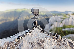 camera mounted on a tripod gorilla with summer mountains in the background