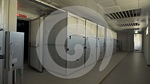 Camera moves along the corridor where there are large wardrobes in which industrial air filters are placed. In the room