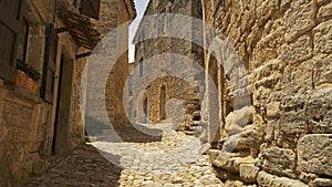 Camera moves along stones street of old town of Lacoste. Walk through picturesque village of Lacoste, Petit Luberon