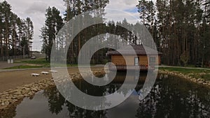 Camera Moves Over Lake Surface to Wooden House