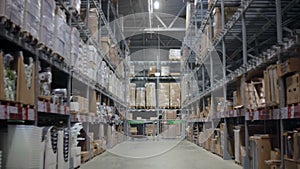 Camera moves between palettes with cardboard boxes and different materials in a storage warehouse