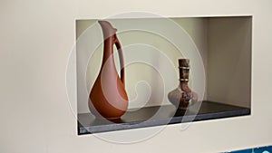 Camera moves from right to left and removes shelves with designer objects.