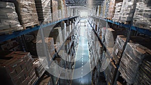 Camera moves up on shelves of cardboard boxes inside a storage warehouse