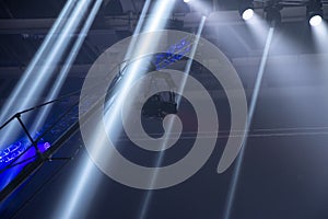 The camera on the operator`s crane flies against the background of bright rays of searchlights.