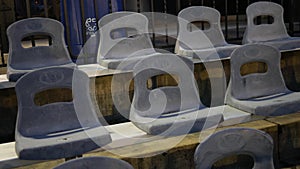 Camera pans over empty chairs at a sporting event at night