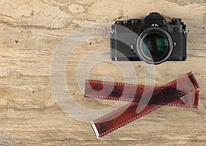 Camera and photographic 35 mm film strip on wood