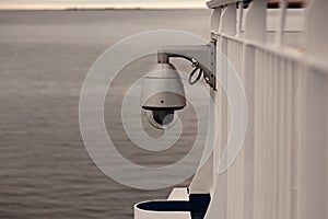 camera at railing on large ferry with sunset in the background