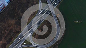 Camera rotating around the car interchange. Aerial view on cars running on the highway and the road. A lot of vehicles ride on the