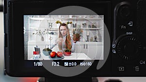 Camera screen recording - Food blogger cooking fresh vegan salad of fruits in kitchen studio, filming tutorial for video