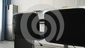 Camera shows an elegant modern kitchen with white walls. Light interior of a white kitchen in a compact apartment, black