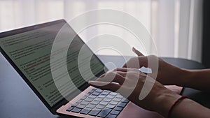 Camera slides around female freelancer's hands typing on laptop keyboard in slow motion. Business woman working at