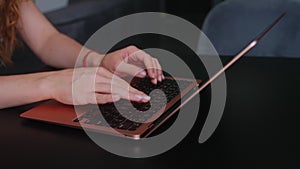 Camera slides around female freelancer's hands typing on laptop keyboard in slow motion. Business woman working at