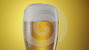Camera slowly rises up along a beer glass with light beer.